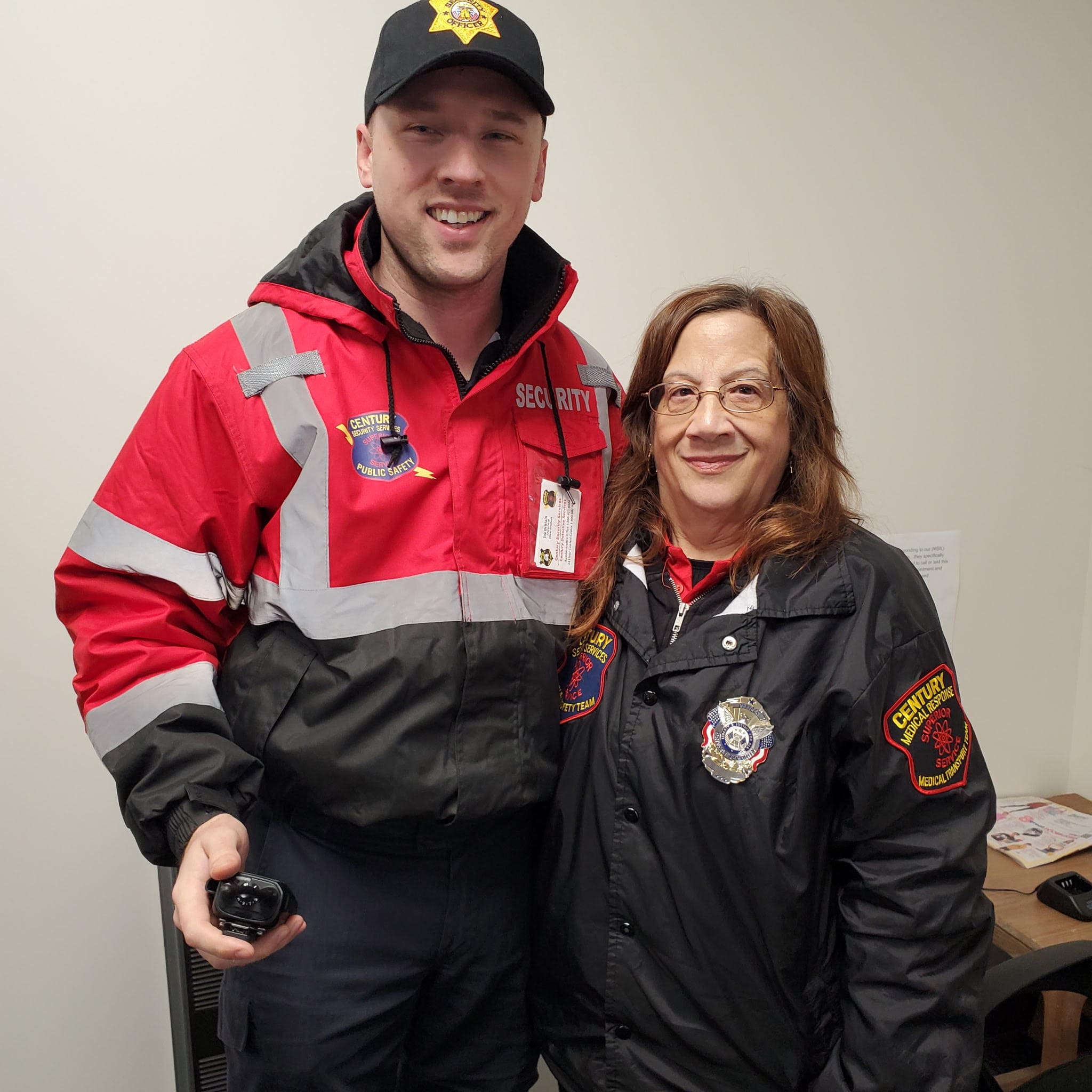 Two security guards stand next to each other.